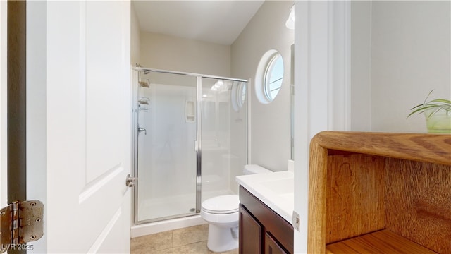 bathroom featuring toilet, a stall shower, tile patterned flooring, and vanity