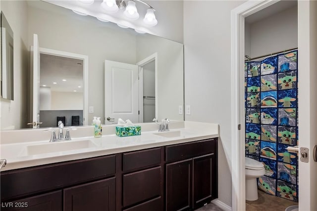 bathroom featuring double vanity, a shower with shower curtain, a sink, and toilet