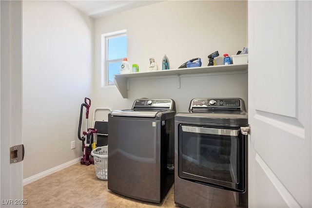 clothes washing area featuring washer and dryer, laundry area, baseboards, and light tile patterned floors