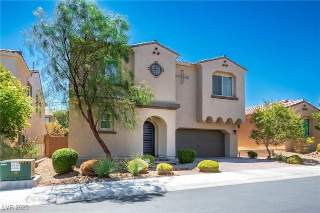 mediterranean / spanish home featuring a garage, decorative driveway, a tile roof, and stucco siding