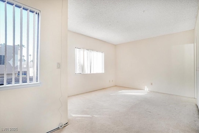 carpeted empty room featuring a textured ceiling