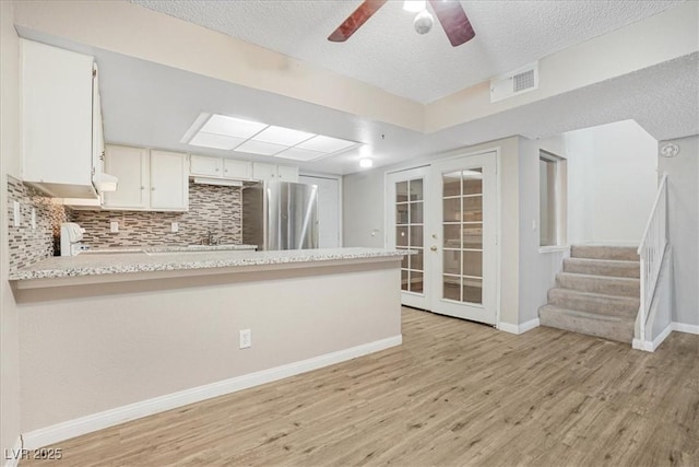 kitchen with light wood finished floors, visible vents, range, and freestanding refrigerator