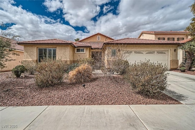 view of front of home with a tile roof, stucco siding, an attached garage, and concrete driveway