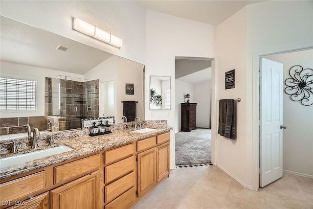 full bathroom featuring a sink, visible vents, lofted ceiling, and a shower stall