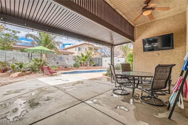 view of patio / terrace with outdoor dining area, a fenced in pool, a fenced backyard, and a ceiling fan