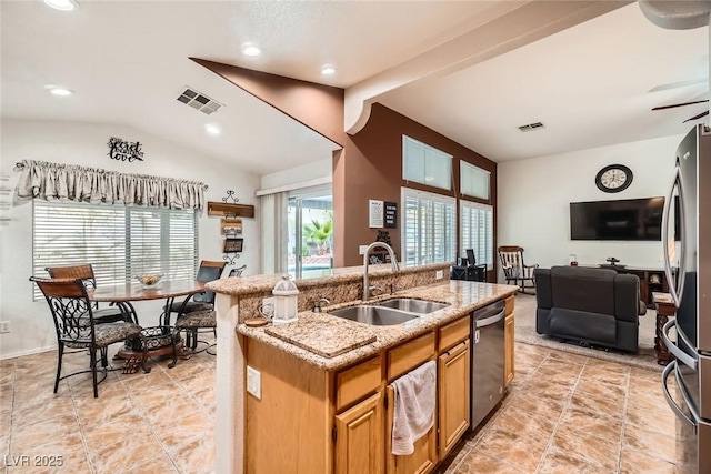 kitchen featuring visible vents, a sink, vaulted ceiling, appliances with stainless steel finishes, and open floor plan