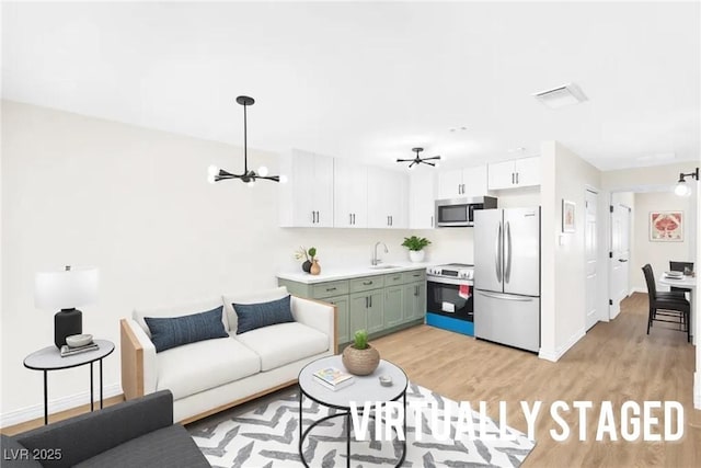 living room with light wood-style floors, baseboards, visible vents, and a notable chandelier