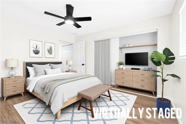 bedroom with ceiling fan, baseboards, and wood finished floors