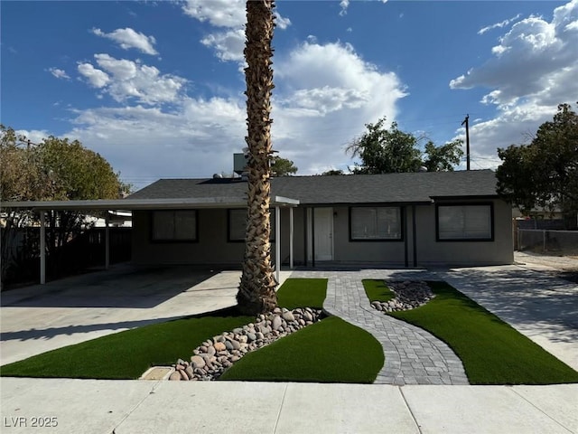 single story home featuring fence, an attached carport, and concrete driveway