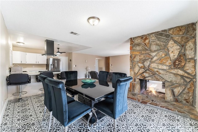 tiled dining space featuring visible vents and a textured ceiling