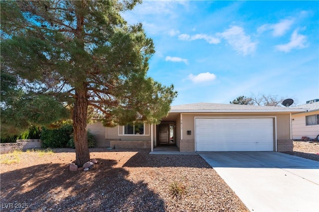 single story home featuring a garage, concrete driveway, and brick siding