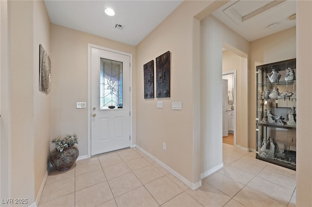 entryway featuring light tile patterned floors, baseboards, and visible vents