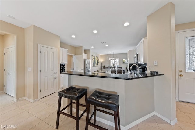 kitchen featuring appliances with stainless steel finishes, dark countertops, white cabinets, and light tile patterned floors