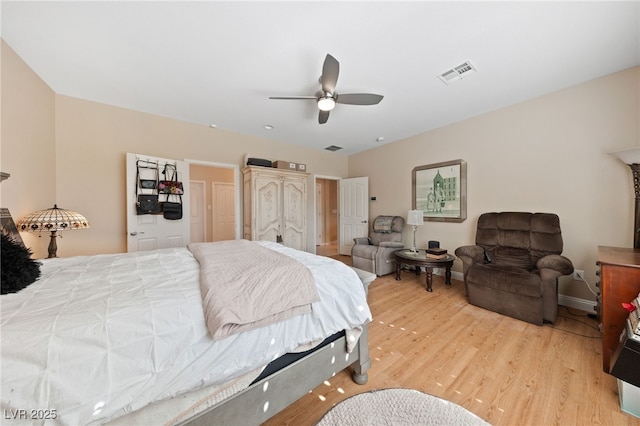 bedroom with light wood-style floors, baseboards, visible vents, and ceiling fan