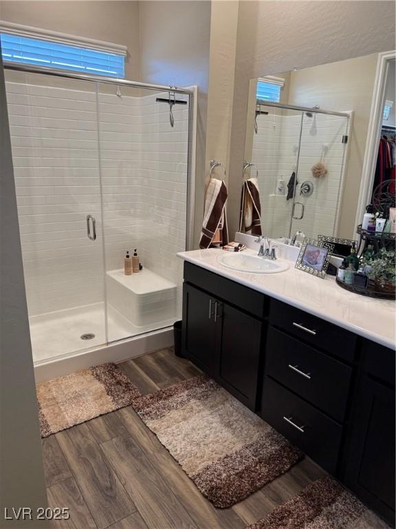 bathroom featuring a stall shower, vanity, and wood finished floors