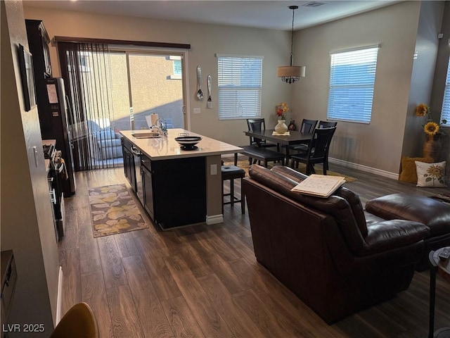 living room featuring dark wood-style flooring, visible vents, and baseboards