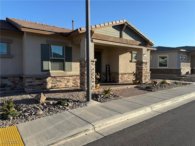 view of front of home featuring stone siding and stucco siding