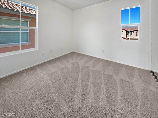 unfurnished room featuring carpet floors and baseboards