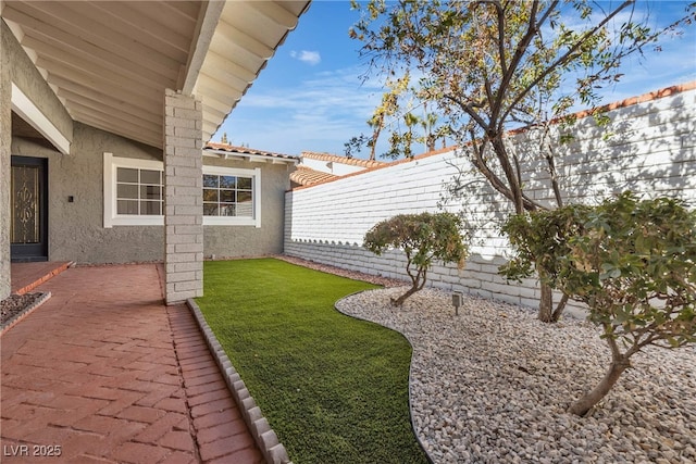 view of yard with fence and a patio