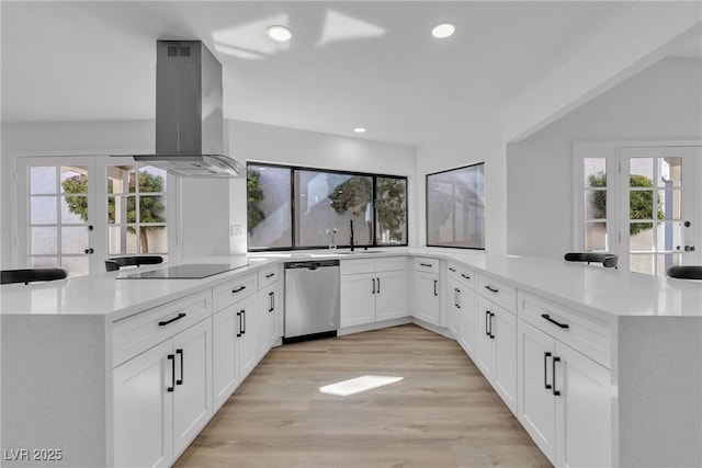 kitchen featuring black electric stovetop, light wood-style flooring, a peninsula, dishwasher, and island exhaust hood