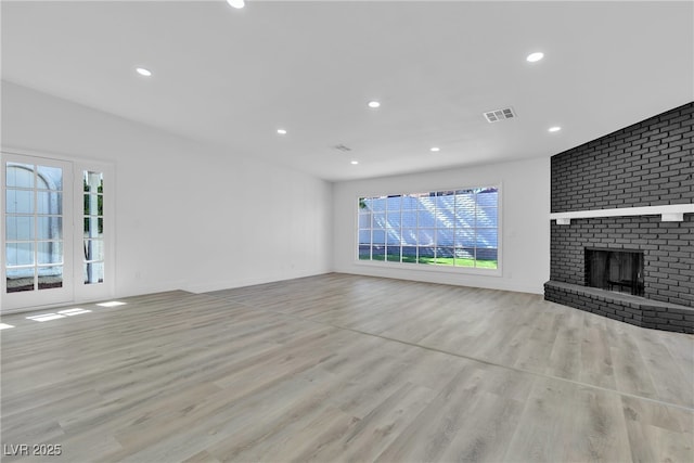 unfurnished living room with a fireplace, wood finished floors, visible vents, and recessed lighting