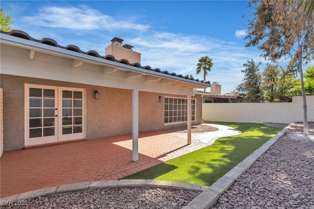 view of yard featuring french doors, fence, and a patio