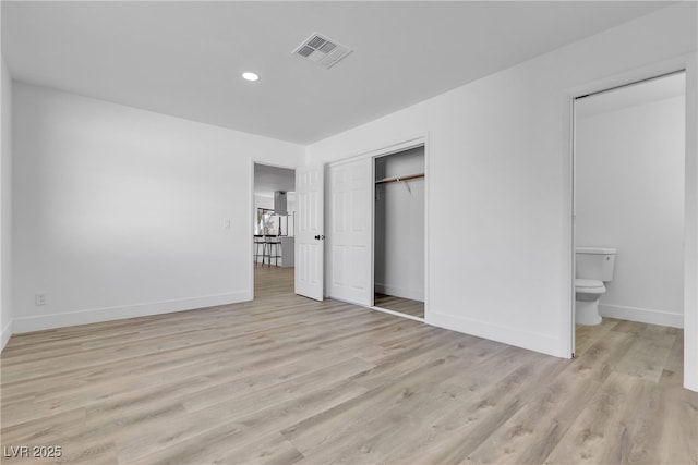 unfurnished bedroom featuring light wood-style floors, baseboards, visible vents, and connected bathroom