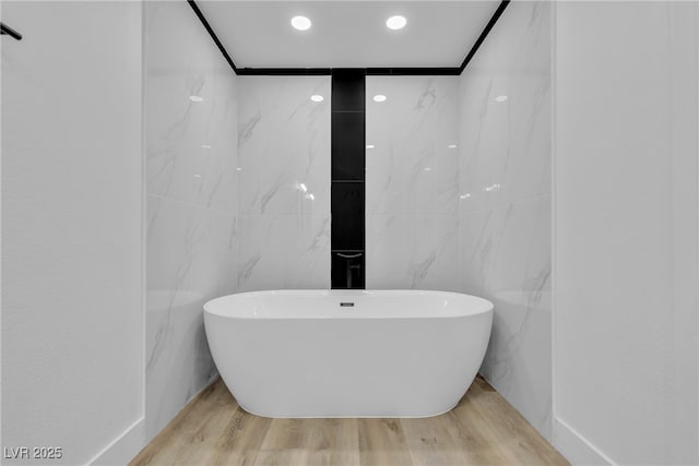 bathroom featuring wood finished floors and a freestanding tub