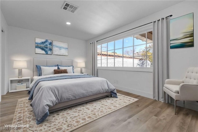 bedroom featuring baseboards, wood finished floors, visible vents, and recessed lighting