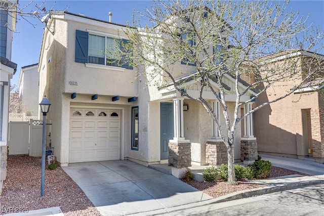 view of front of property with concrete driveway, an attached garage, fence, and stucco siding