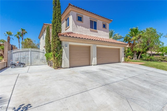 mediterranean / spanish-style home featuring a garage, concrete driveway, a tile roof, and stucco siding