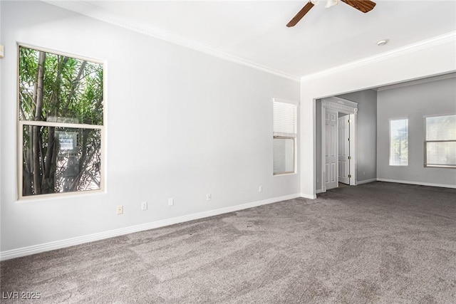 carpeted spare room featuring ornamental molding, a ceiling fan, and baseboards