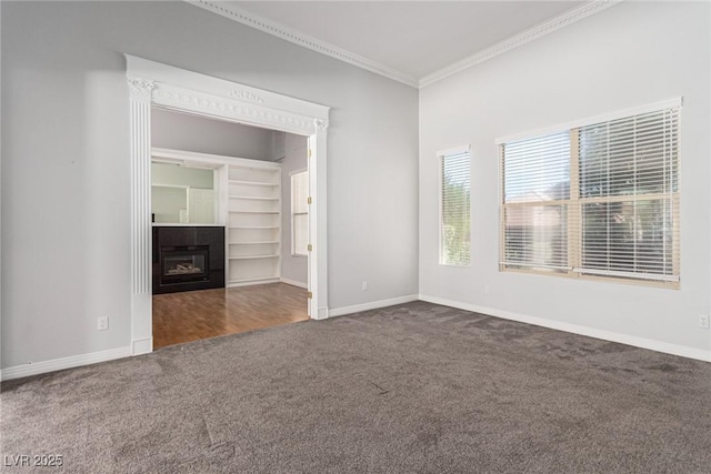 unfurnished living room featuring carpet floors, crown molding, baseboards, and a tiled fireplace