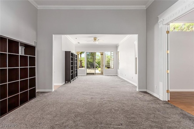 unfurnished living room with ornamental molding, carpet flooring, ceiling fan, and baseboards