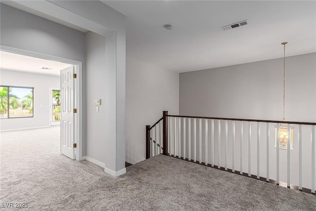 hallway with baseboards, visible vents, carpet flooring, and an upstairs landing