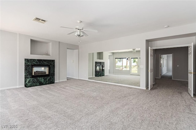 unfurnished living room featuring visible vents, baseboards, ceiling fan, carpet, and a high end fireplace