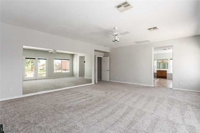 carpeted empty room featuring ceiling fan, visible vents, and baseboards