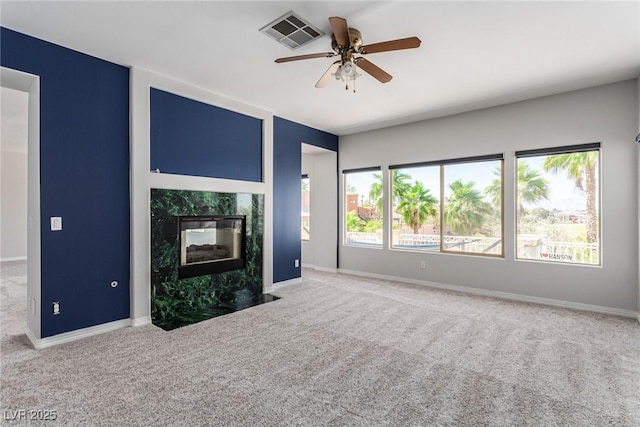 unfurnished living room featuring baseboards, visible vents, a fireplace, and carpet flooring