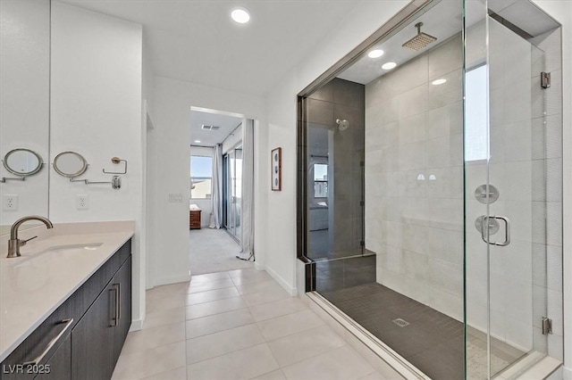 bathroom featuring ensuite bathroom, a stall shower, vanity, tile patterned flooring, and baseboards