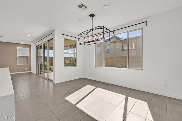 spare room featuring a notable chandelier, tile patterned flooring, visible vents, and baseboards