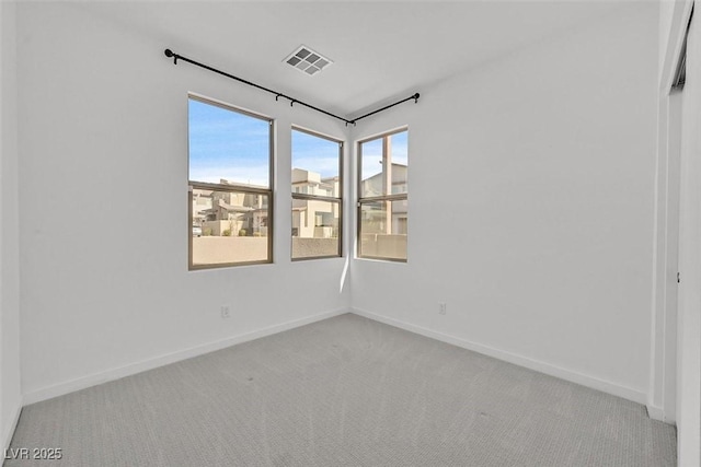 spare room with visible vents, baseboards, and carpet flooring