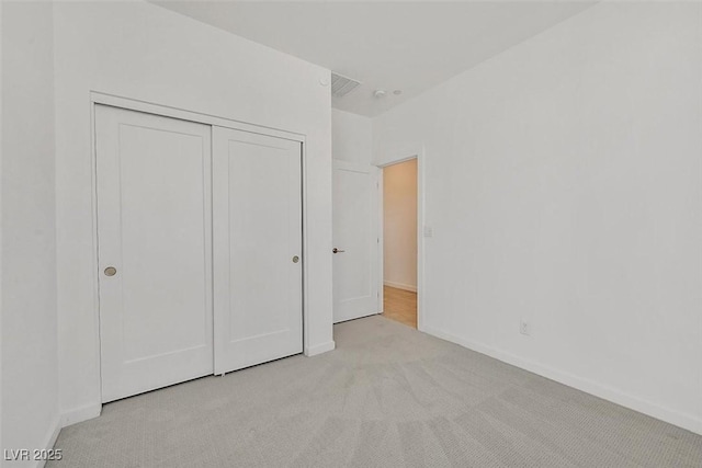 unfurnished bedroom featuring carpet, visible vents, baseboards, and a closet