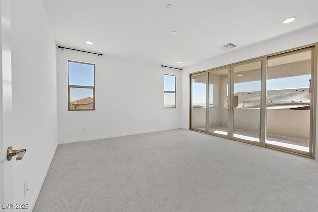 unfurnished room featuring carpet floors, a wealth of natural light, visible vents, and recessed lighting