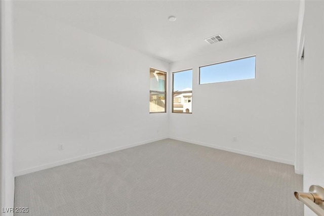 unfurnished room with carpet flooring, visible vents, and baseboards