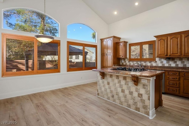 kitchen with light wood-style floors, backsplash, and a center island