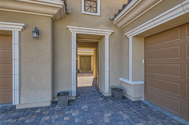 view of exterior entry featuring stucco siding