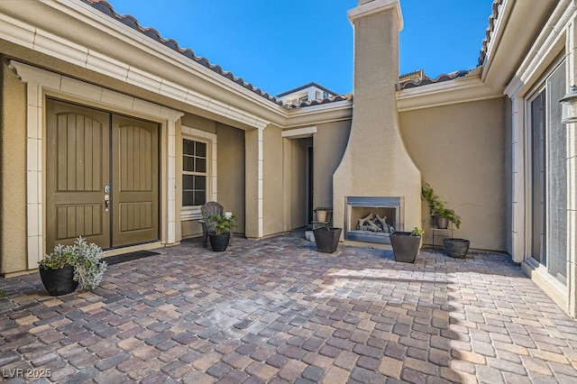 view of patio with exterior fireplace