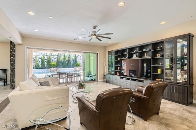 living area with ceiling fan, baseboards, and recessed lighting