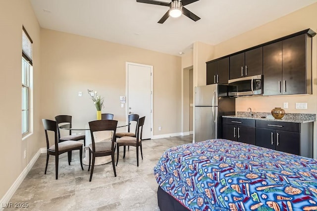 bedroom with baseboards, a sink, and freestanding refrigerator