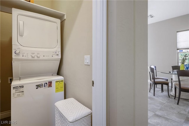 laundry room with laundry area, visible vents, and stacked washer / dryer